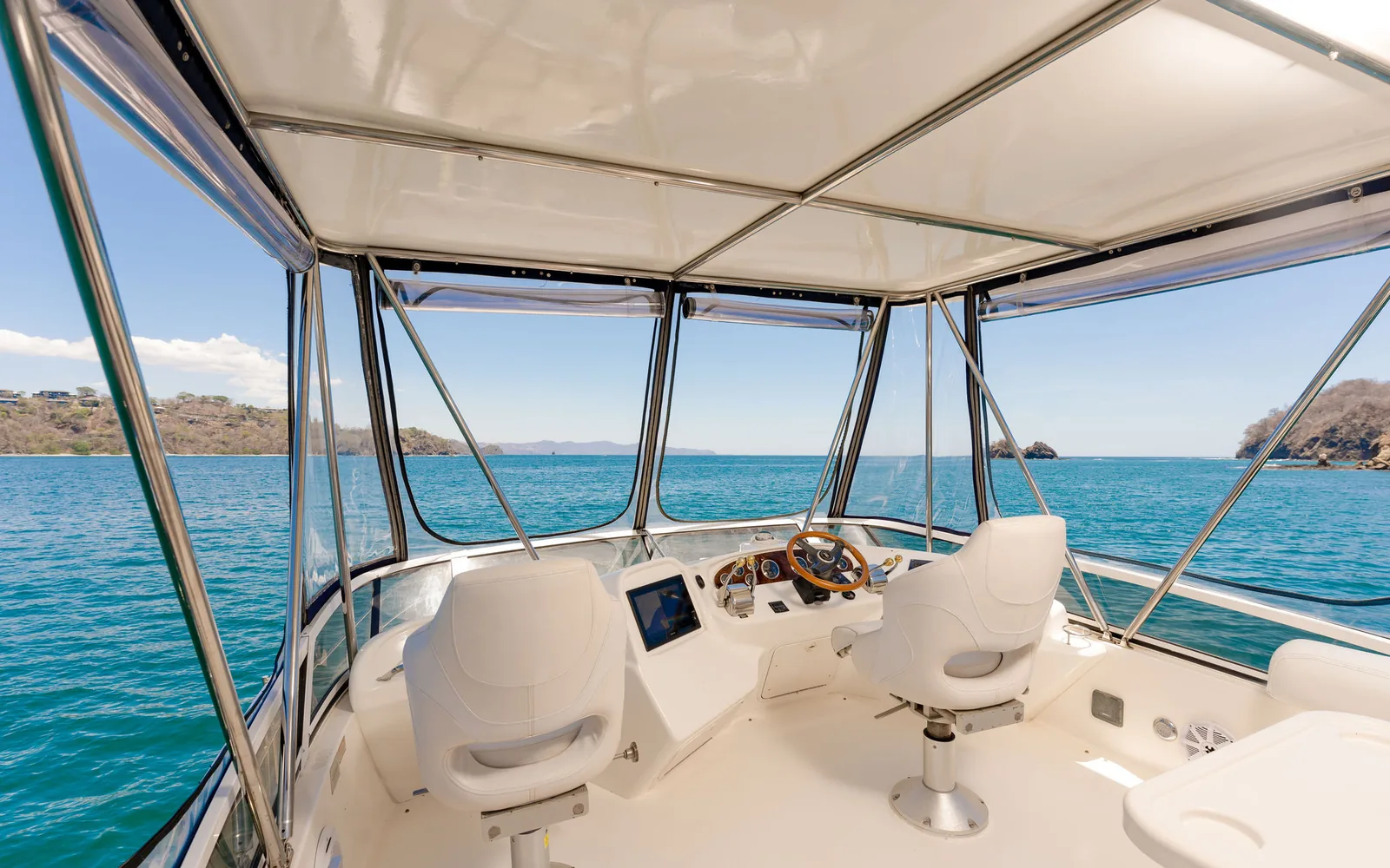 Sea Ya, an Ocean Club flybridge motor yacht with teak aft-deck dining, on Costa Rica's Pacific coast