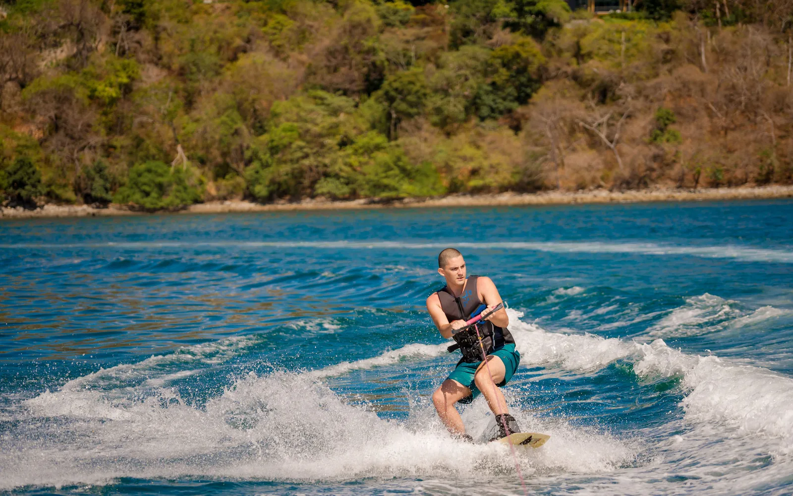 A wakeboarder behind an Ocean Club tender on calm water off Costa Rica's Pacific coast